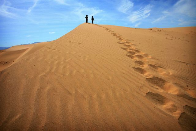 Brendan Hughes and Danielle Segura of Mojave Desert Land Trust make their way down a sand dune at Cadiz Dunes in Mojave Trails National Monument in this March 2016 file photo. (File photo by Kurt Miller, Riverside Press-Enterprise/SCNG)